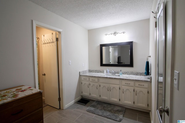 1822 Oakleaf Ln, Center Point, AL 35215 - bathroom featuring vanity, a textured ceiling, a walk in closet, and tile patterned flooring