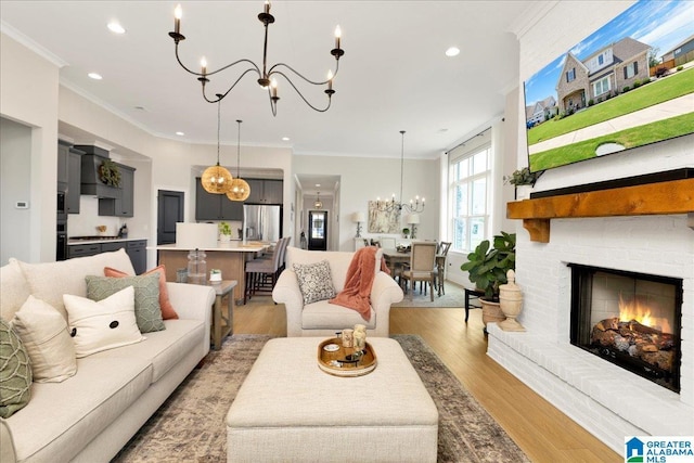 4549 Brexton St, Trussville, AL 35173 - living area featuring a chandelier, recessed lighting, light wood finished floors, crown molding, and a brick fireplace