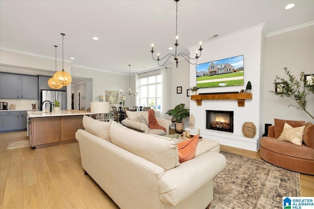 4549 Brexton St, Trussville, AL 35173 - living area featuring a chandelier, light wood-type flooring, recessed lighting, ornamental molding, and a large fireplace