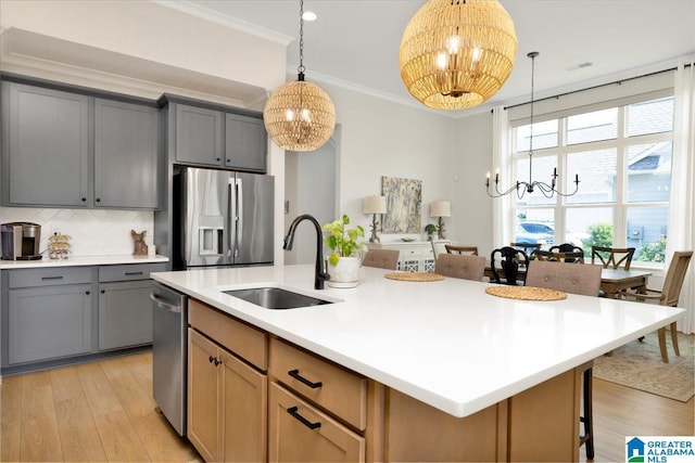 4549 Brexton St, Trussville, AL 35173 - kitchen featuring a chandelier, appliances with stainless steel finishes, light wood-type flooring, gray cabinets, and crown molding