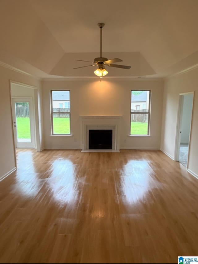2312 Dunbar Cir, Moody, AL 35004 - unfurnished living room featuring a raised ceiling, ceiling fan, light wood finished floors, and a fireplace with flush hearth