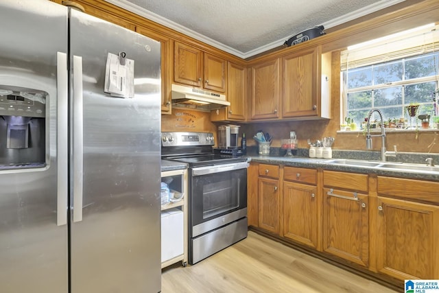 7839 Old Bradford Rd, Pinson, AL 35126 - kitchen with stainless steel appliances, under cabinet range hood, brown cabinets, dark countertops, and light wood finished floors