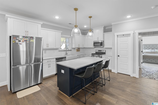 2024 Adams Ridge Dr, Chelsea, AL 35043 - kitchen with stainless steel appliances, crown molding, white cabinets, light countertops, and dark wood-type flooring