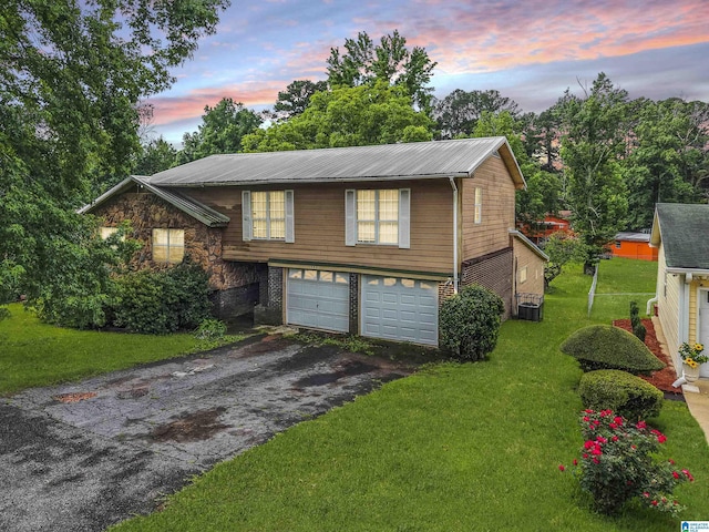 540 Harlem Ave, Hueytown, AL 35023 - view of front of home with driveway, an attached garage, a front yard, and a metal roof