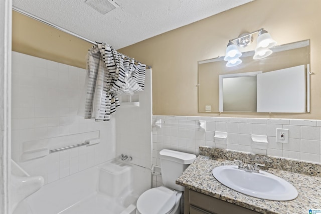 540 Harlem Ave, Hueytown, AL 35023 - full bath with vanity, tile walls, a textured ceiling, shower / bath combination with curtain, and a wainscoted wall