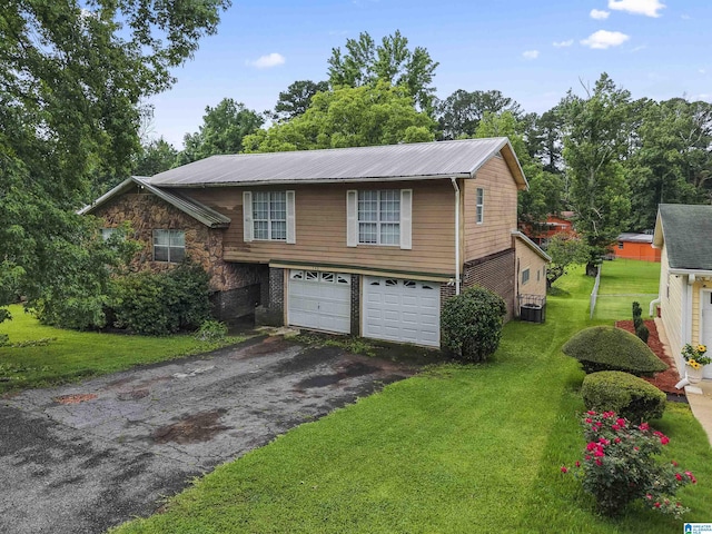 540 Harlem Ave, Hueytown, AL 35023 - view of front facade with asphalt driveway, an attached garage, a front yard, and a metal roof