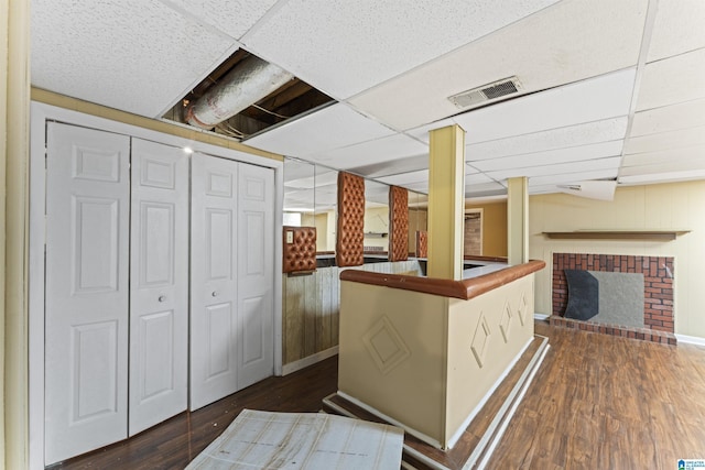 540 Harlem Ave, Hueytown, AL 35023 - kitchen featuring dark wood finished floors, a fireplace, a paneled ceiling, and wooden walls