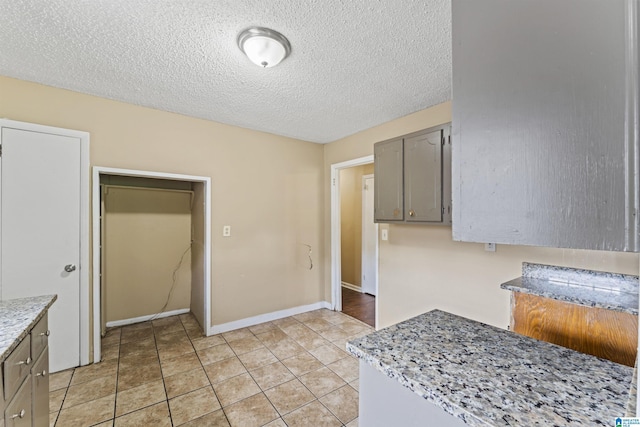 540 Harlem Ave, Hueytown, AL 35023 - kitchen featuring gray cabinets, light countertops, a textured ceiling, and light tile patterned flooring