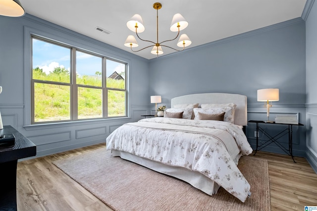 200 Simms Lndg, Pelham, AL 35124 - bedroom featuring a decorative wall, a chandelier, multiple windows, wood finished floors, and ornamental molding