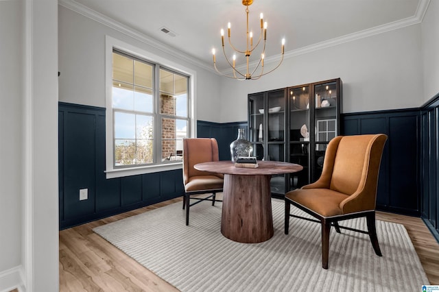 200 Simms Lndg, Pelham, AL 35124 - dining area featuring a chandelier, light wood-style flooring, a wainscoted wall, crown molding, and a decorative wall