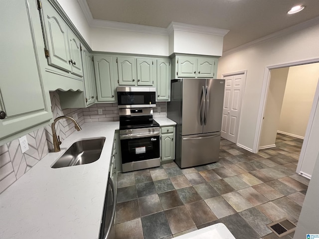 3041 Old Stone Dr, Birmingham, AL 35242 - kitchen featuring appliances with stainless steel finishes, green cabinetry, ornamental molding, tasteful backsplash, and stone finish floors