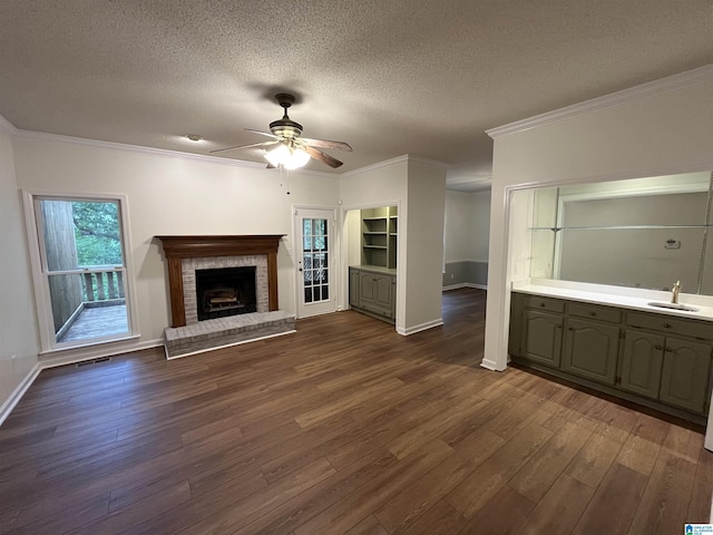 3041 Old Stone Dr, Birmingham, AL 35242 - unfurnished living room featuring a ceiling fan, dark wood finished floors, a brick fireplace, a textured ceiling, and crown molding