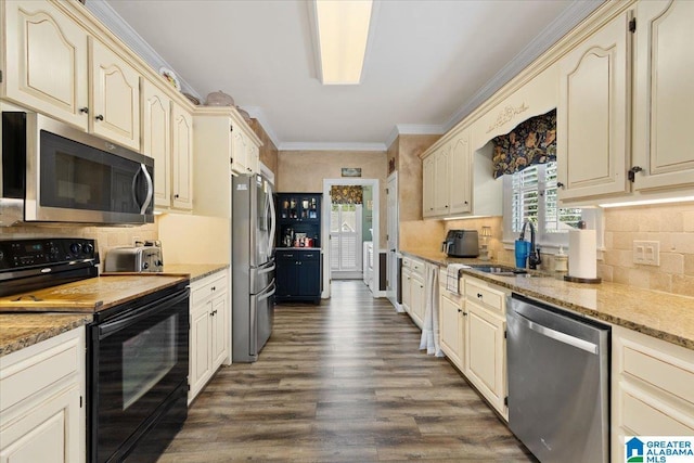 315 Roundabout Dr, Trussville, AL 35173 - kitchen with appliances with stainless steel finishes, cream cabinetry, dark wood finished floors, backsplash, and ornamental molding