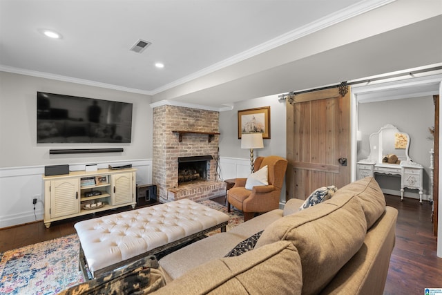 2440 Regent Ln, Hoover, AL 35226 - living room with crown molding, dark wood-style flooring, a barn door, a wainscoted wall, and recessed lighting