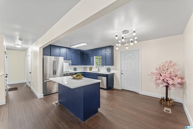 2649 6th St NE, Center Point, AL 35215 - kitchen featuring stainless steel appliances, blue cabinetry, light countertops, dark wood-style flooring, and a kitchen island