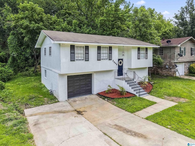 2649 6th St NE, Center Point, AL 35215 - bi-level home with concrete driveway, a front yard, a garage, brick siding, and a shingled roof