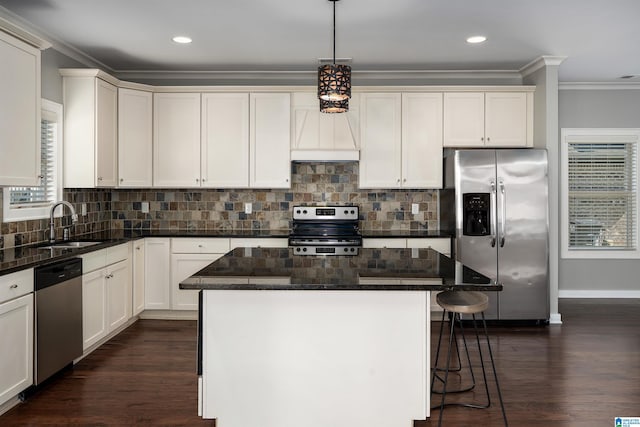 5181 Cruise St, Trussville, AL 35173 - kitchen with appliances with stainless steel finishes, crown molding, a kitchen bar, a kitchen island, and tasteful backsplash