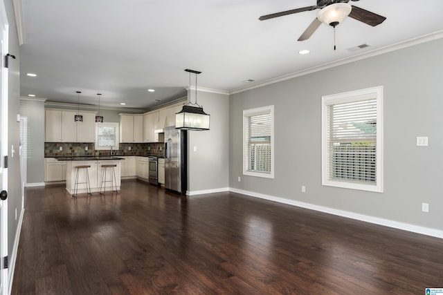 5181 Cruise St, Trussville, AL 35173 - kitchen featuring dark countertops, stainless steel appliances, decorative backsplash, dark wood-type flooring, and ornamental molding