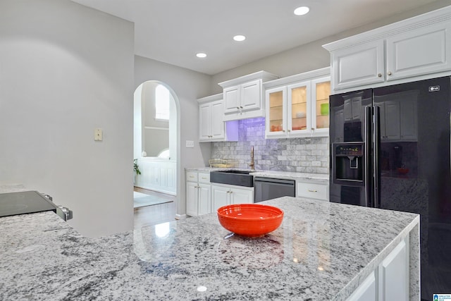 2816 Aster Lake Rd, Helena, AL 35022 - kitchen featuring black refrigerator with ice dispenser, white cabinets, stainless steel dishwasher, glass insert cabinets, and light stone counters