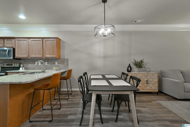 1186 Inverness Cove Way, Hoover, AL 35242 - dining area with ornamental molding, a chandelier, dark wood finished floors, and recessed lighting