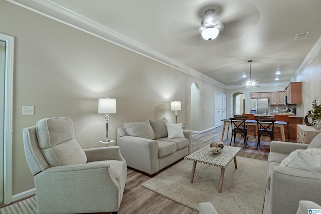 1186 Inverness Cove Way, Hoover, AL 35242 - living area with arched walkways, crown molding, light wood-style flooring, and ceiling fan