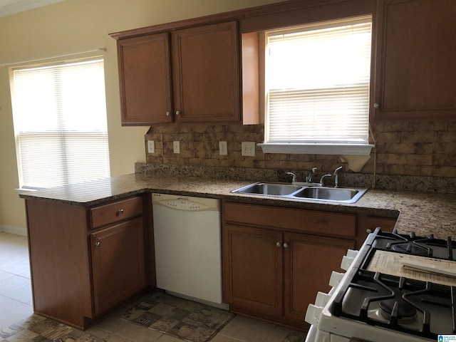 155 Highview Cv, Pelham, AL 35124 - kitchen with white dishwasher, a peninsula, backsplash, range with gas cooktop, and brown cabinetry