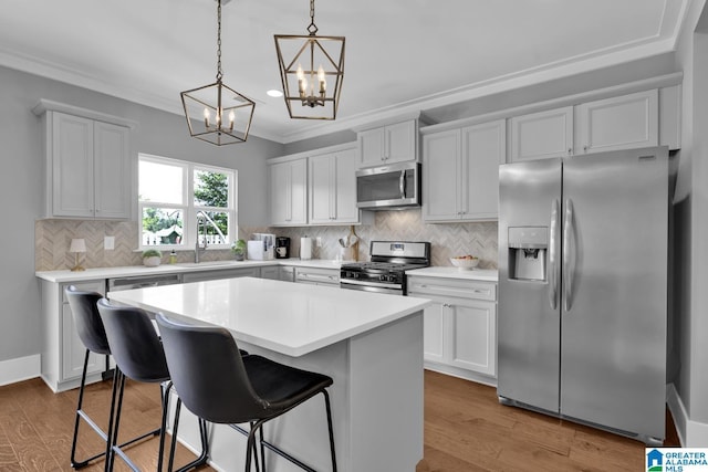 7808 Jayden Dr, Trussville, AL 35173 - kitchen featuring appliances with stainless steel finishes, a chandelier, a center island, a breakfast bar, and crown molding