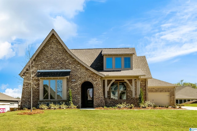 500 Simms Lndg, Pelham, AL 35124 - tudor home featuring brick siding, a front yard, a garage, driveway, and roof with shingles