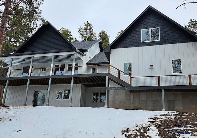 snow covered back of property featuring a balcony