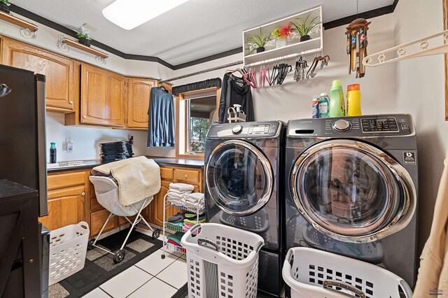 laundry area with cabinets, light tile floors, ornamental molding, a textured ceiling, and separate washer and dryer