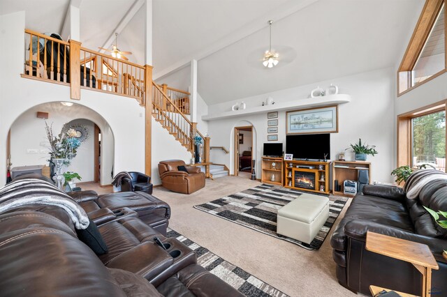 carpeted living room with ceiling fan, high vaulted ceiling, and beam ceiling