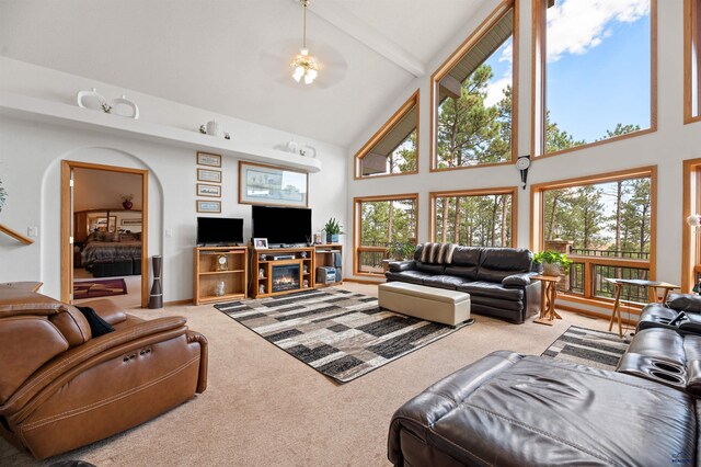 carpeted living room featuring ceiling fan, high vaulted ceiling, and beam ceiling