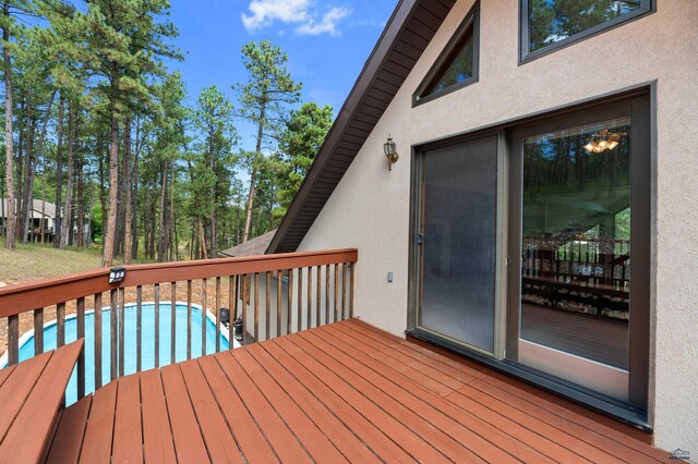 wooden deck with a fenced in pool