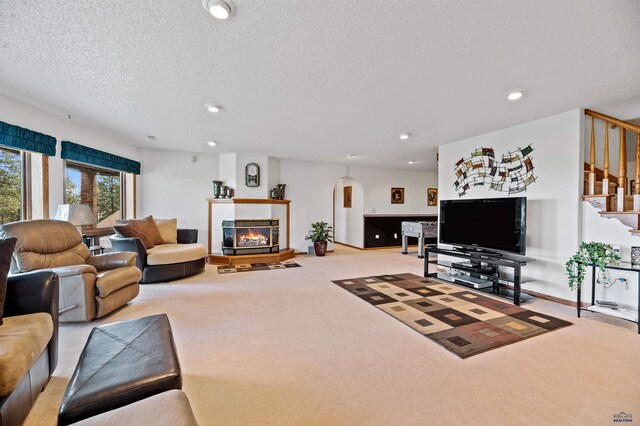 carpeted living room featuring a textured ceiling