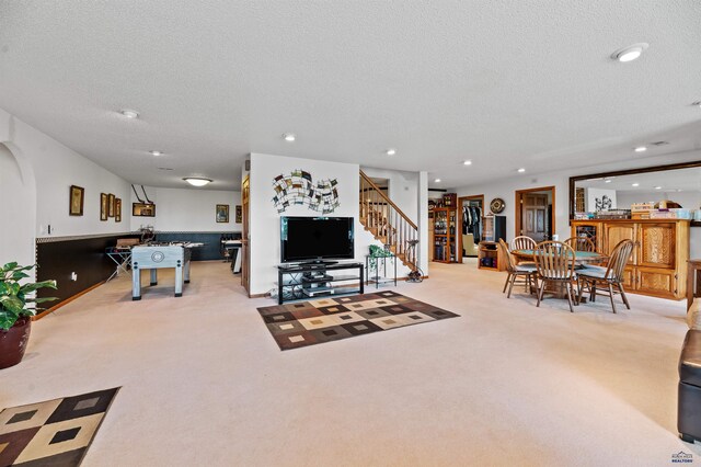 carpeted living room featuring a textured ceiling