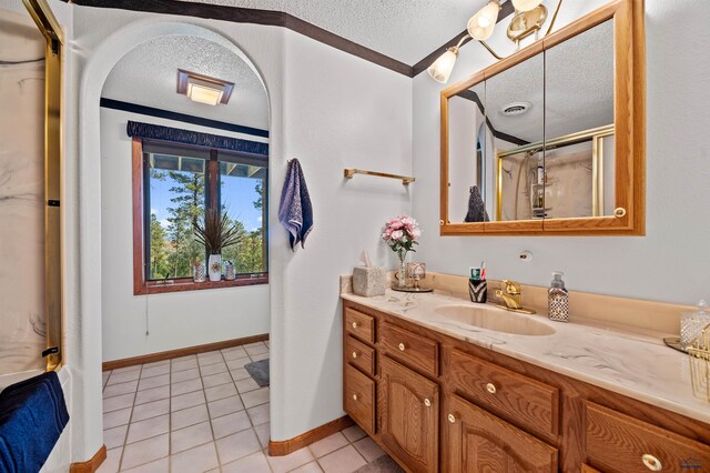 bathroom featuring tile flooring, vanity, and a textured ceiling