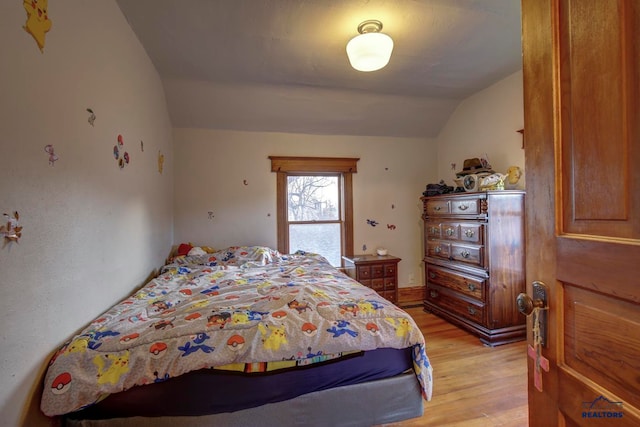 bedroom featuring light hardwood / wood-style flooring and vaulted ceiling