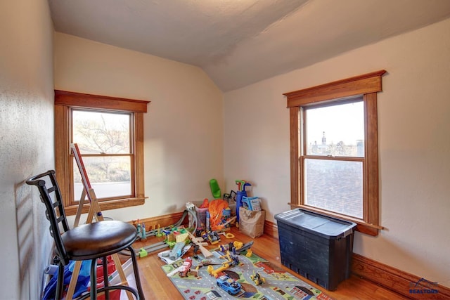 rec room featuring light hardwood / wood-style floors and lofted ceiling