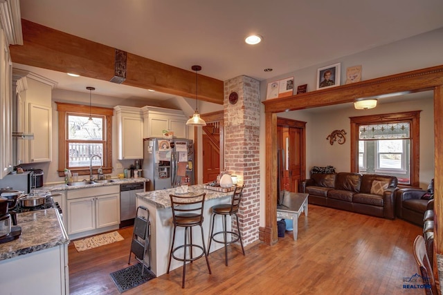 kitchen featuring hanging light fixtures, stainless steel appliances, a wealth of natural light, and dark hardwood / wood-style floors