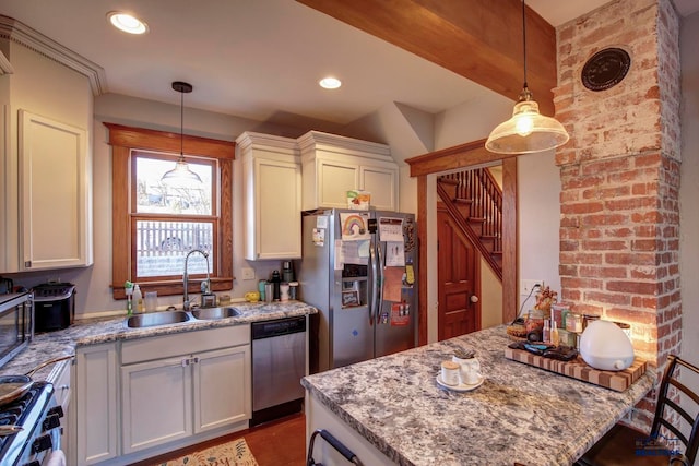 kitchen with brick wall, appliances with stainless steel finishes, light stone countertops, and sink