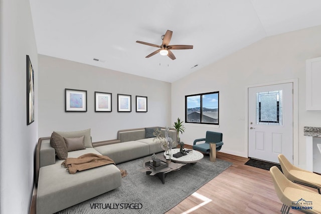 living room with light hardwood / wood-style floors, vaulted ceiling, and ceiling fan