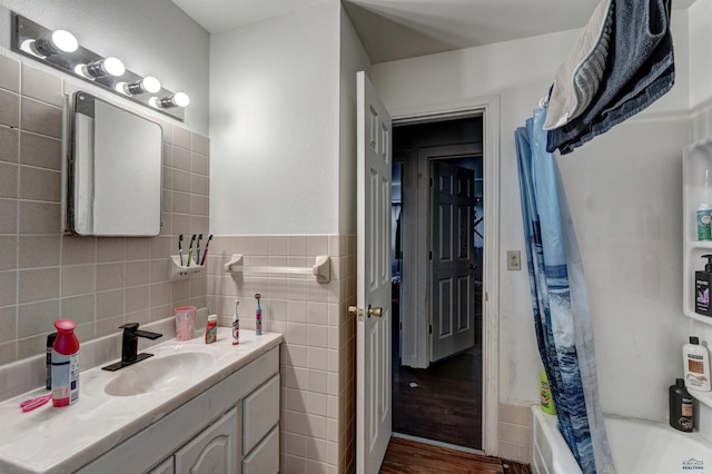 601 Haines Ct, Rapid City, SD 57701 - bathroom featuring backsplash, tile walls, vanity, and wood-type flooring
