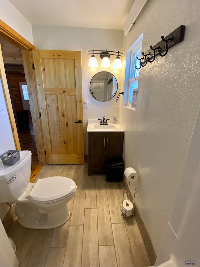 bathroom featuring vanity, wood-type flooring, and toilet