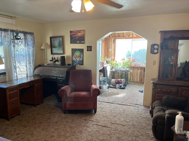 carpeted living room with ceiling fan