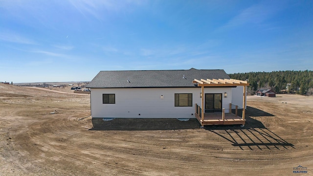 rear view of property featuring a wooden deck