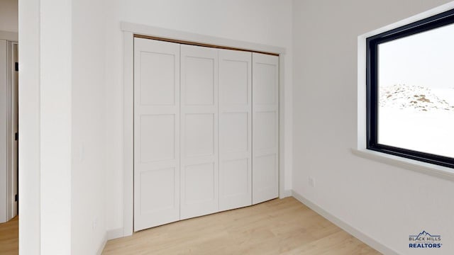 unfurnished bedroom with a closet and light hardwood / wood-style floors