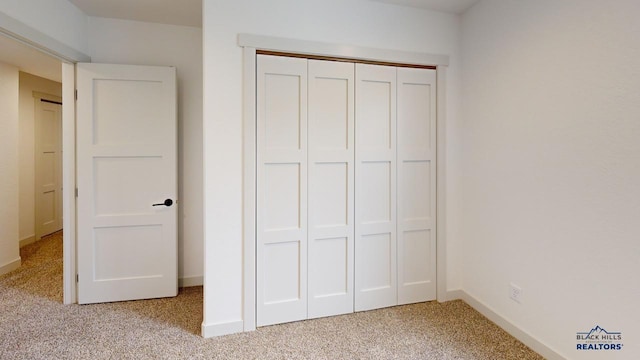 unfurnished bedroom featuring light carpet and a closet