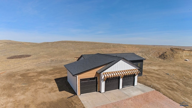 view of front facade featuring a garage and a rural view