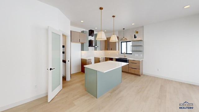 kitchen with light hardwood / wood-style flooring, tasteful backsplash, pendant lighting, a kitchen island, and sink