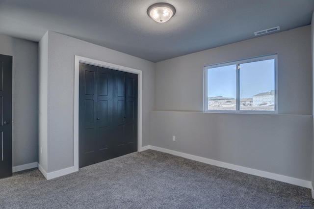 unfurnished bedroom with light carpet and a closet